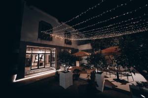 a building with lights and a patio with tables and trees at Ananea Tropea Yachting Resort in Tropea