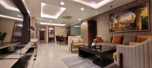 een woonkamer met een bank en een tafel bij Goldcrest Luxury Apartments in Lahore