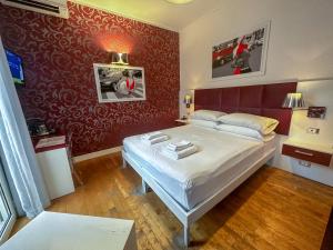 a bedroom with a bed and a red wall at B&B Pellicano Guest House in Reggio di Calabria