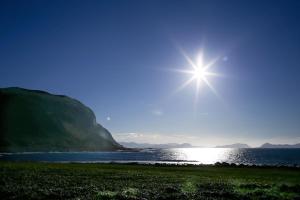 une étoile brillante dans le ciel au-dessus d'une masse d'eau dans l'établissement Alnes Gård, à Ålesund