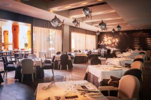 a dining room with white tables and chairs at Royal Hideaway Sancti Petri in Chiclana de la Frontera