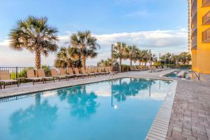 basen z krzesłami i palmami w ośrodku w obiekcie Hilton Grand Vacations Club Anderson Ocean Myrtle Beach w mieście Myrtle Beach