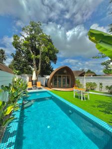 una piscina frente a una villa en Found Mansion, en Pantai Cenang