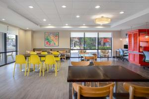 a dining room with tables and yellow chairs at Home2 Suites By Hilton Gainesville in Gainesville