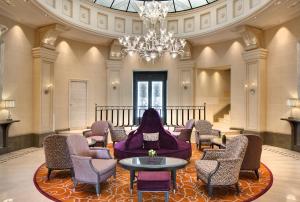 a large lobby with chairs and a chandelier at Hôtel Château Frontenac in Paris