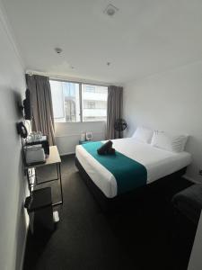 a hotel room with a bed with a green blanket at No. 9 Hotel in Auckland