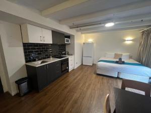 a bedroom with a bed and a kitchen with a sink at No. 9 Hotel in Auckland