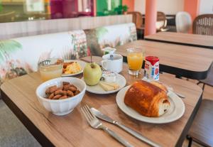 - une table en bois avec des aliments pour le petit-déjeuner et des boissons dans l'établissement B&B HOTEL Strasbourg Nord Mundolsheim, à Mundolsheim