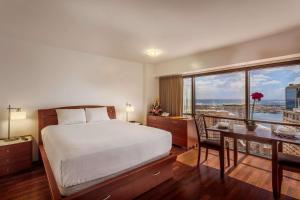 a bedroom with a bed and a desk and a table with a desk at Aston at the Executive Centre Hotel in Honolulu