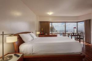 a bedroom with a large bed and a balcony at Aston at the Executive Centre Hotel in Honolulu