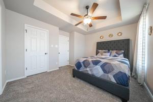 Schlafzimmer mit einem Bett und einem Deckenventilator in der Unterkunft Gorgeous, Brand New 3 Bedrooms Home- Built 2024, Near SeaWorld & Lackland AFB in San Antonio