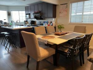 a kitchen with a table and chairs in a kitchen at Vancouver Airport Cozy room 舒适小屋, Richmond,near YVR in Richmond