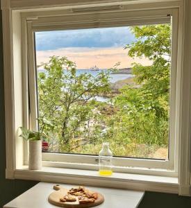 una finestra con un piatto di cibo su un tavolo di Idyllisk enebolig! a Svolvær