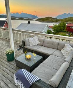 un divano e un tavolo su una terrazza con vista sull'oceano di Idyllisk enebolig! a Svolvær