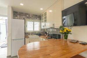 a kitchen with a wooden table with a vase of flowers at Hotel The Cathedral Vegueta in Las Palmas de Gran Canaria