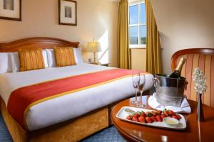 um quarto de hotel com uma cama e uma bandeja de frutas em Killarney Plaza Hotel & Spa em Killarney