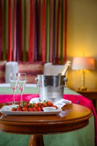 uma mesa com um prato de comida e dois copos de vinho em Killarney Plaza Hotel & Spa em Killarney