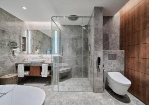 a bathroom with a shower and a toilet and a sink at Sunway Resort Hotel in Kuala Lumpur