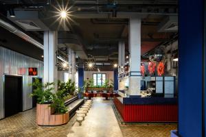 a lobby of a restaurant with potted plants at CX Milan Bicocca in Milan