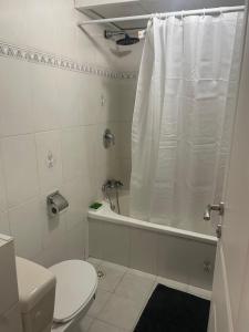 uma casa de banho com um WC e uma banheira com uma cortina de chuveiro em Llalis luxury em Eilat