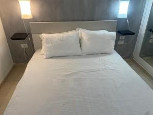 uma grande cama branca com duas almofadas em Llalis luxury em Eilat