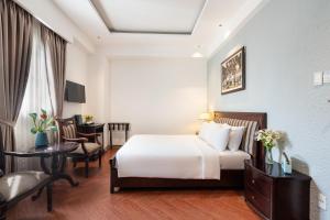 una camera d'albergo con letto e scrivania di Nicecy Hotel - Bui Thi Xuan Street ad Ho Chi Minh