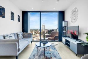 Mercian Luxury Aparthotel - Birmingham City Centre - Your Perfect Stay - 24 Hour Gym Rooftop Terrace Cinema Room في برمنغهام: غرفة معيشة مع أريكة وطاولة