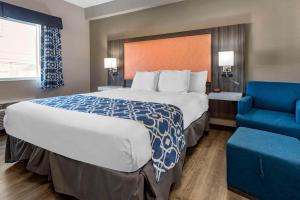 een hotelkamer met een groot bed en een blauwe stoel bij The Waves Hotel, Ascend Hotel Collection in Wildwood