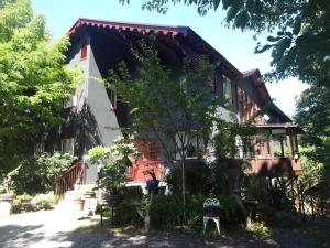 a house with a tree in front of it at IZUNA INN & SPA - the veggie delights in Ito