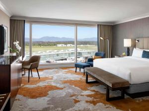 a hotel room with a bed and a large window at Fairmont Vancouver Airport In-Terminal Hotel in Richmond