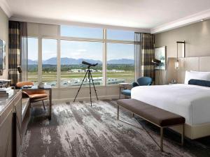 a hotel room with a bed and a camera at Fairmont Vancouver Airport In-Terminal Hotel in Richmond