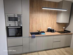 a kitchen with a counter with a microwave and a stove at Apartman AURA self CHECK-IN, FREE PRIVATE PARKING in Osijek