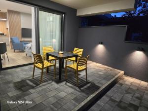 a dining room with yellow chairs and a table at Apartman AURA self CHECK-IN, FREE PRIVATE PARKING in Osijek