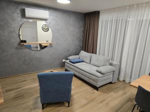 a living room with a couch and a mirror at Apartman AURA self CHECK-IN, FREE PRIVATE PARKING in Osijek