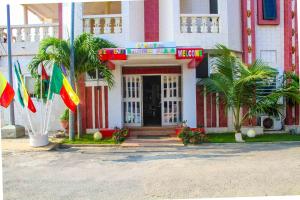 un hotel con banderas frente a un edificio en Hotel Bariba playa, en Cotonou