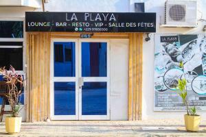 un edificio con una puerta con un cartel. en Hotel Bariba playa, en Cotonou