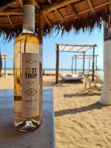 Una botella de vino sentada en una mesa en la playa en Hotel Bariba playa, en Cotonou