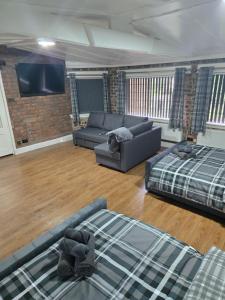 a living room with a couch and a bed at Rainsough Cottage Guest House - Sleeps upto 8 with ensuite - Free Parking & WiFi in Manchester