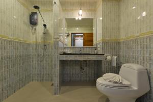 a bathroom with a toilet and a sink and a mirror at Princess River Kwai Hotel in Kanchanaburi City