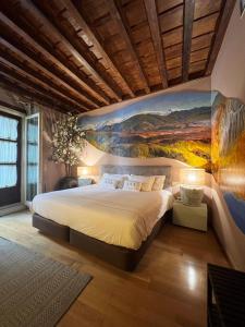 a bedroom with a large bed with a painting on the wall at Gar Anat Hotel Boutique in Granada