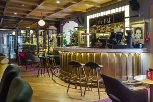 a bar in a restaurant with stools around it at Browns Central Hotel in Lisbon