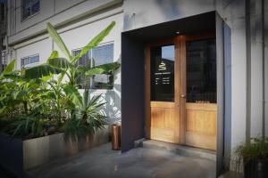 una porta d'ingresso di un edificio con piante di Lemonsea Onomichi a Onomichi