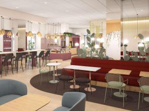 a restaurant with tables and chairs and a counter at Ibis Styles Strasbourg Centre République in Strasbourg