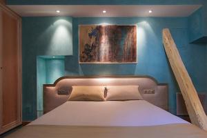 a bed in a bedroom with a blue wall at Hotel Cathédrale in Strasbourg