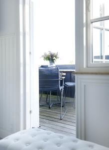 a table and a chair in a room with a window at Hotel Villa Brinkly in Snekkersten