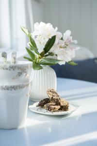 a plate of cookies and a vase with flowers on a table at Hotel Villa Brinkly in Snekkersten