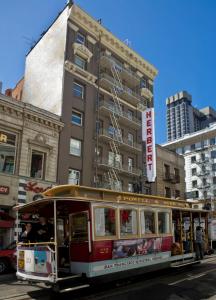 a trolley car driving down a city street at Herbert Hotel in San Francisco