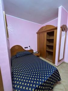 a bedroom with a bed and a wooden cabinet at Hotel Canada in Falerna Marina