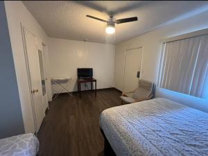 - une chambre avec un lit et un ventilateur de plafond dans l'établissement Flamingo Motel - San Ysidro, à San Diego