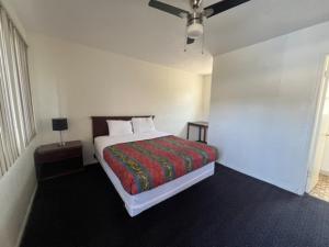 - une chambre avec un lit et une couverture rouge dans l'établissement Flamingo Motel - San Ysidro, à San Diego